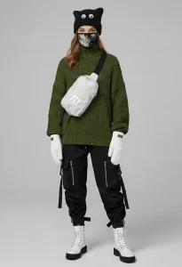 Woman wearing Shadow Moss winter streetwear outfit by FLY Clothing featuring olive green knit sweater and monster eye beanie