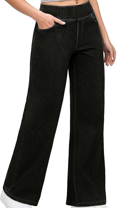 A person wearing high-waisted, black denim pull-on baggy jeans with a wide-leg cut and an elastic waistband, paired with white sneakers and a grey crop top.