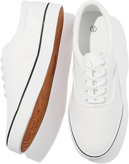 A pair of low-top men’s white canvas sneakers featuring a clean lace-up front, silver-tone metal eyelets, a reinforced rubber toe cap, and a thick vulcanized white rubber sole with a subtle Fly Clothing Co. logo on the heel.