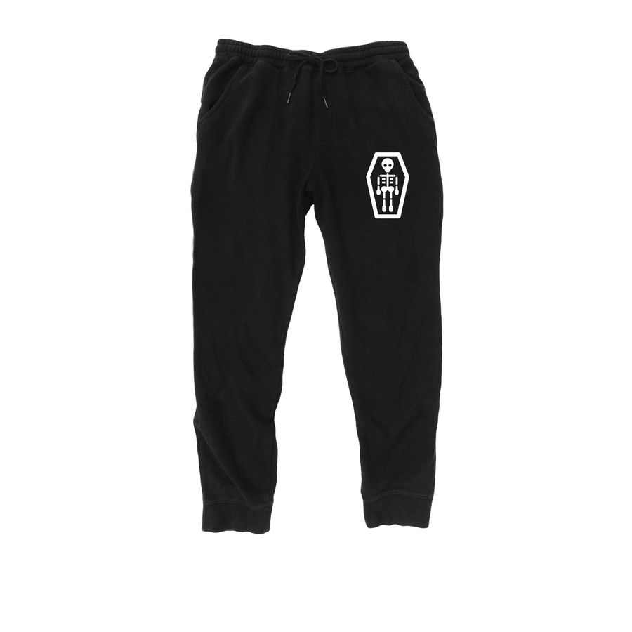 A pair of black heavyweight joggers featuring a white anatomical skeleton leg graphic on the left thigh and a vertical row of stylized coffin silhouettes on the right calf, complete with a drawstring waist and tapered ribbed cuffs.