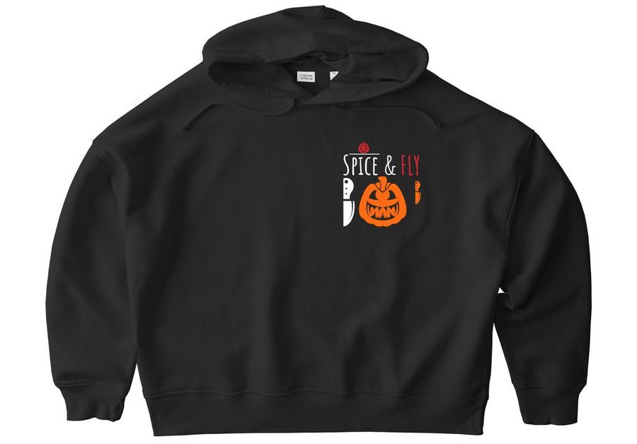 "A front-facing view of the Spice + Fly Halloween Hoodie by FLY Clothing Co. The oversized black hoodie features a large circular graphic on the chest with a stylized, smiling jack-o'-lantern face. Below the pumpkin, the text reads 'SPICE + FLY' in a distressed, collegiate-style font. The hoodie includes a front kangaroo pocket and ribbed cuffs, displayed on a clean white background."