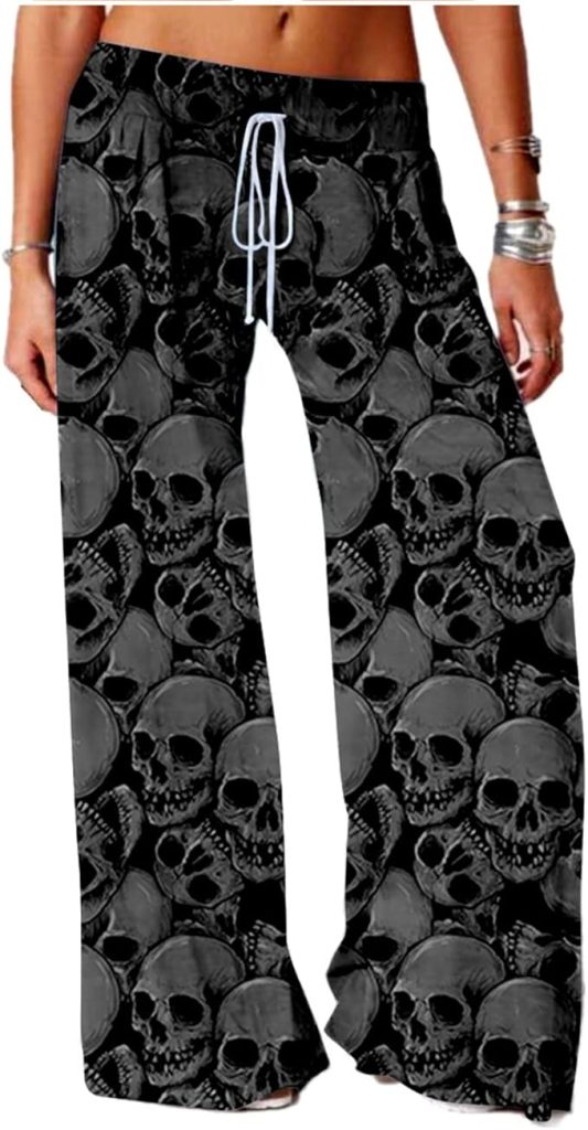 A pair of wide-leg black lounge pants featuring an all-over gray scale print of realistic human skulls. The pants have an elastic waistband with a white drawstring.