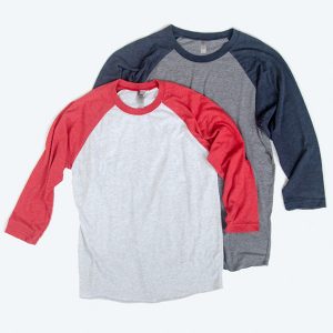 Two blank 3/4 sleeve baseball raglan t-shirts, one with red sleeves and a heather white body and another with navy sleeves and a charcoal heather body, ready for custom design services.