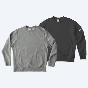 Two custom Nike Club Fleece Crewneck Sweatshirts in heather grey and anthracite black, featuring the Nike swoosh on the left sleeve, part of the Fly Clothing Co design service in LA and NYC.