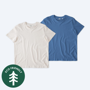 Two blank Stanley Stella unisex Crafter t-shirts, one in a natural off-white and one in a vibrant mid-blue, displayed on a clean white background with a green "Eco Friendly" tree icon for custom apparel design services.