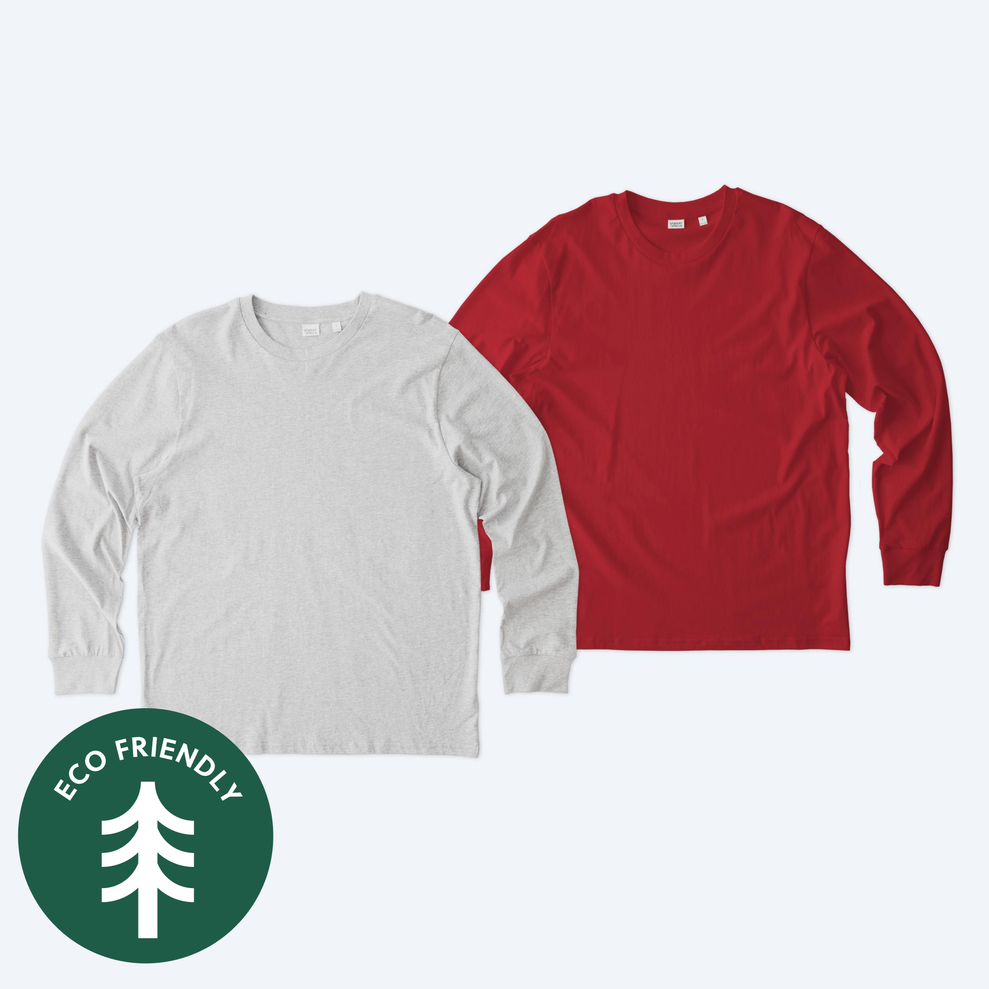 Two blank Stanley Stella Unisex Creator 2.0 long sleeve t-shirts, one in heather grey and one in vibrant red, featuring a modern retail fit and an eco-friendly badge for custom apparel design services.