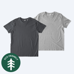 Two blank Stanley Stella unisex Rocker t-shirts, one in a deep anthracite grey and one in a classic heather grey, featuring a modern retail fit and displayed on a clean white background with a green "Eco Friendly" tree icon for custom apparel design services.