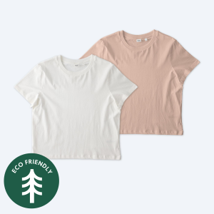 Two blank Stanley Stella Women’s Stella Muser t-shirts, one in crisp optic white and one in soft petal pink, displayed on a clean white background with a green "Eco Friendly" tree icon for custom apparel design services.