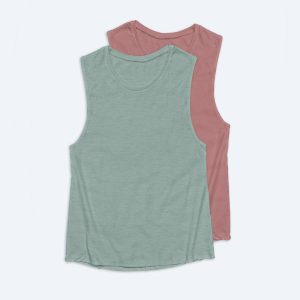 Two blank women's muscle tank tops in dusty rose and sage green colors, featuring wide armholes and a relaxed fit, displayed on a white background for custom apparel design services.