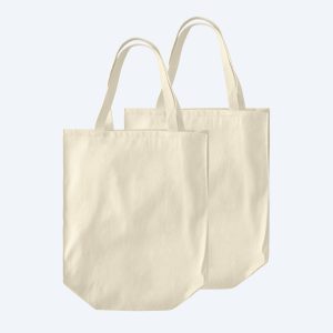 Two blank large organic cotton over-the-shoulder shopping tote bags in a natural ecru cream, featuring spacious structured bases and displayed on a clean white background for custom branding design services.